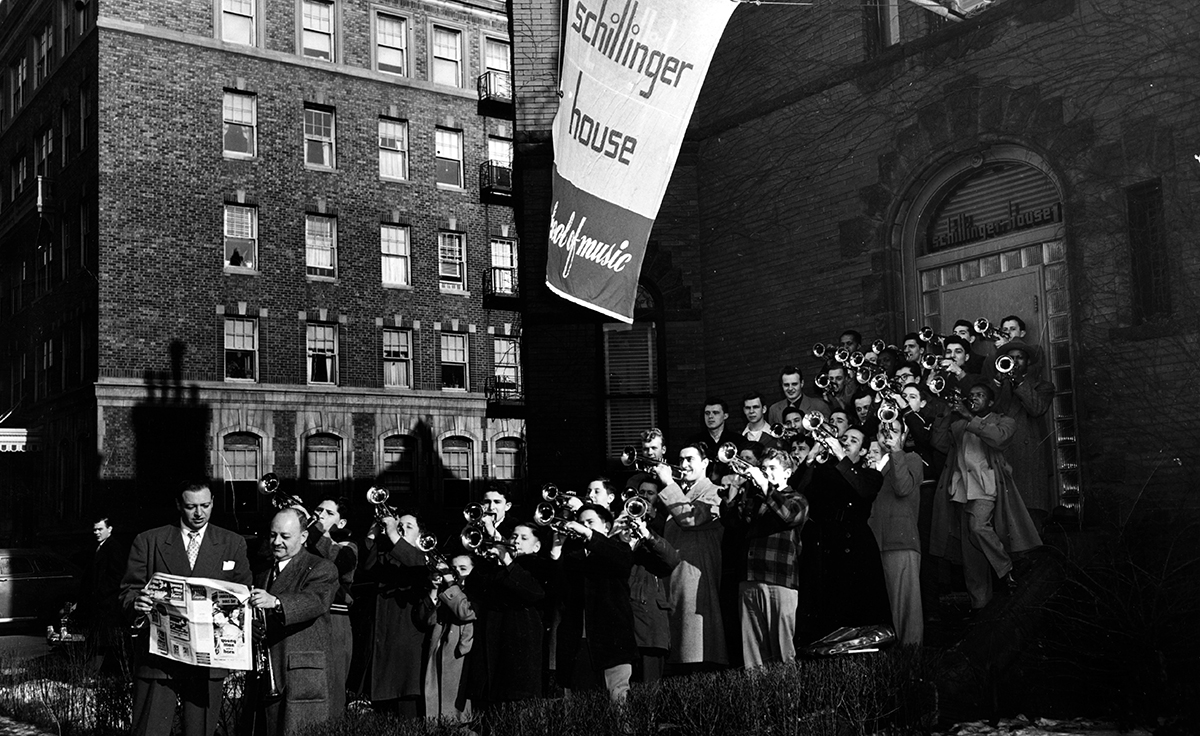 Brass students on the steps of Schillinger House. Supervisor of Brass Instruction Fred Berman stands at the head of the group (second from right, holding a newspaper).