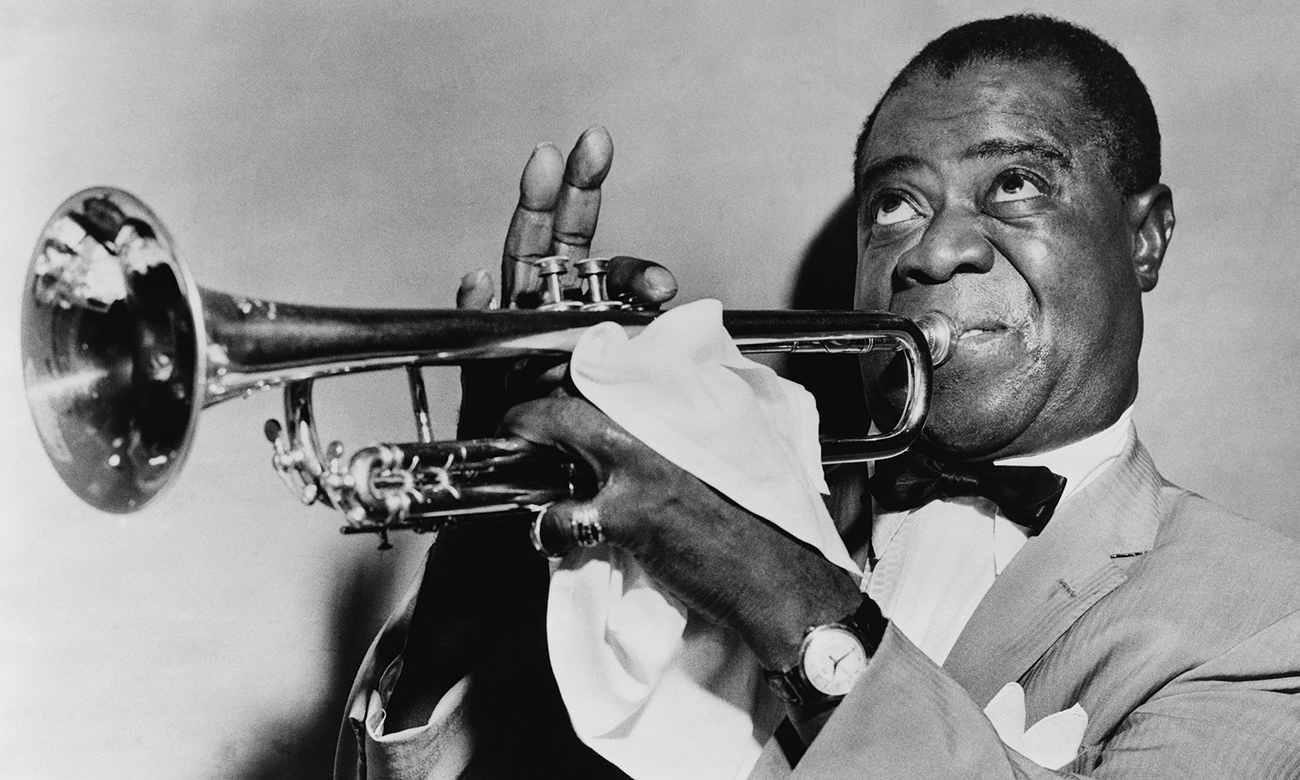 Black and white photograph of Louis Armstrong playing the trumpet.
