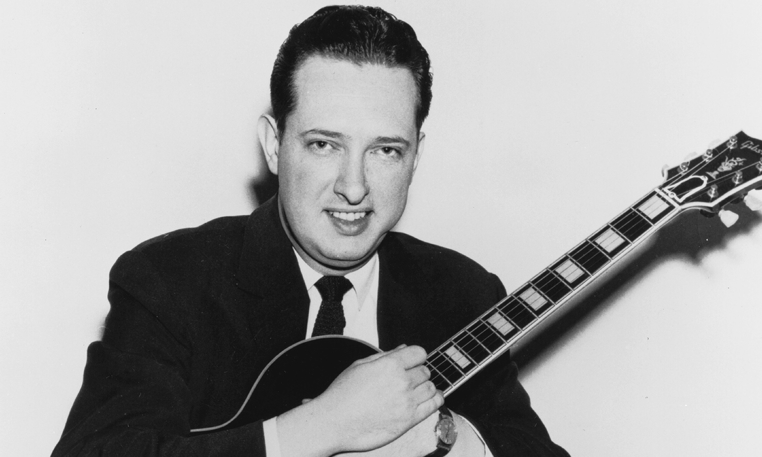 Black and white photograph of Bill Leavitt holding a guitar.