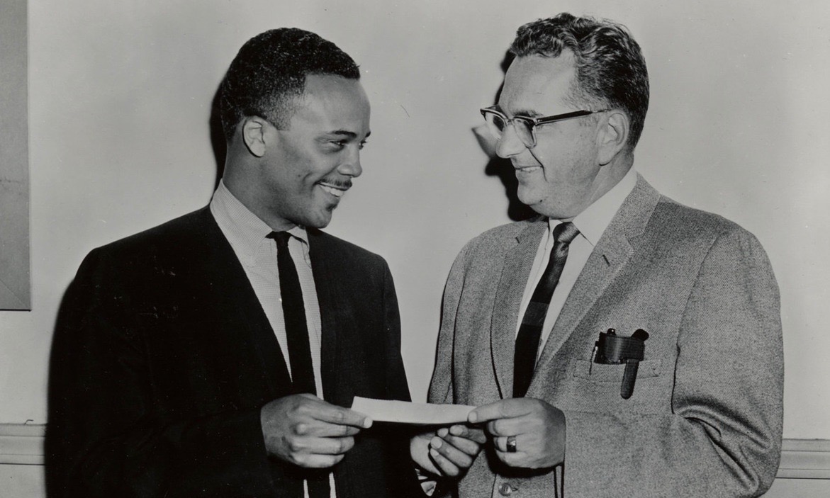Photograph of Quincy Jones presenting Lawrence Berk with a check.
