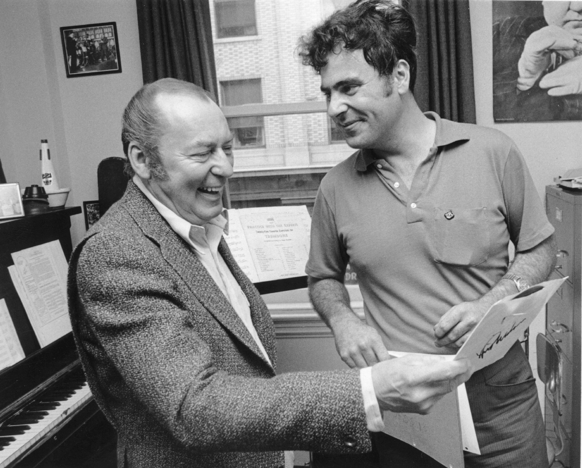 Black and white photograph of two men laughing and talking.