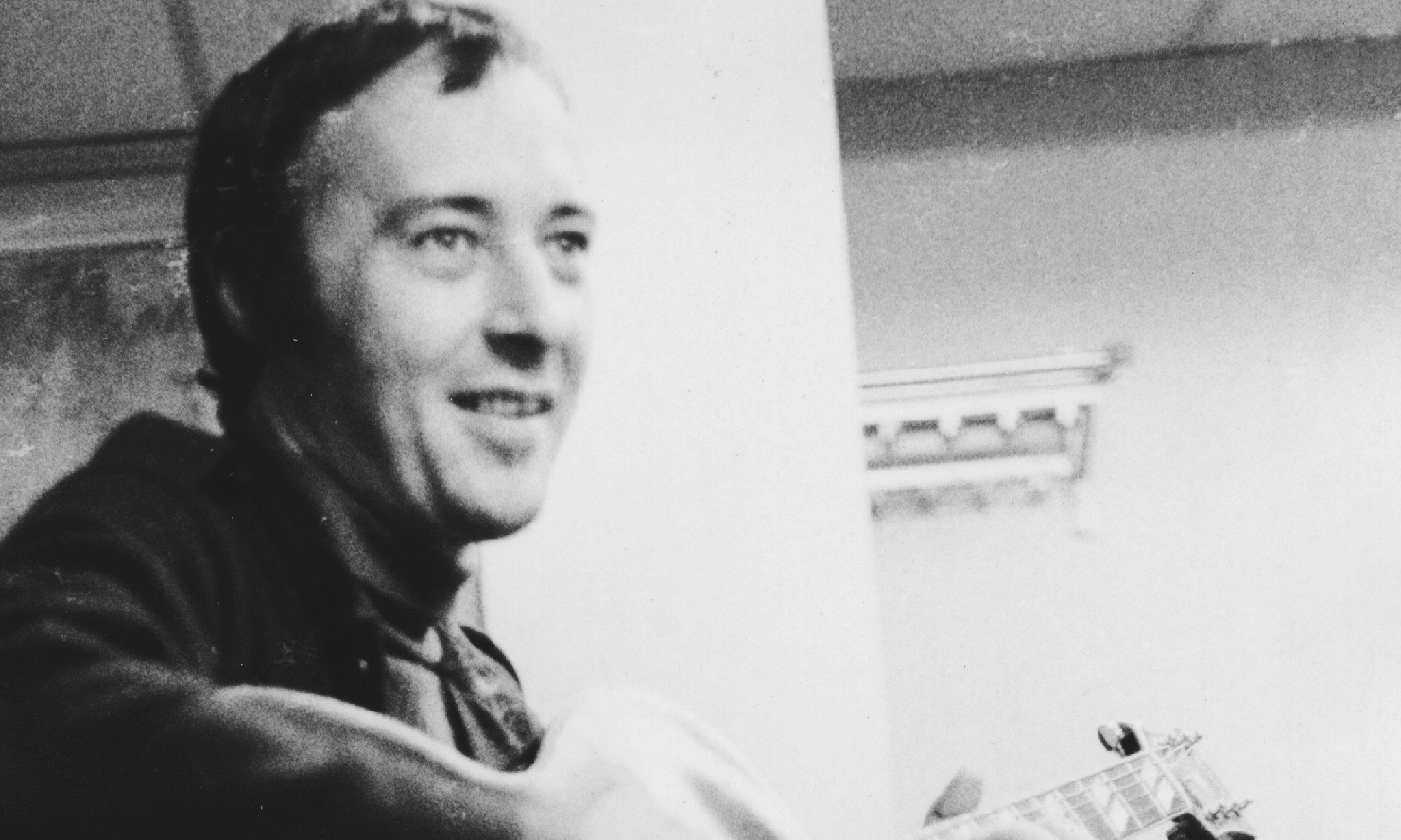 Black and white portrait of Gábor Szabó playing guitar.