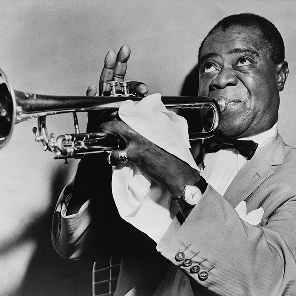 Black and white photograph of Louis Armstrong playing the trumpet.