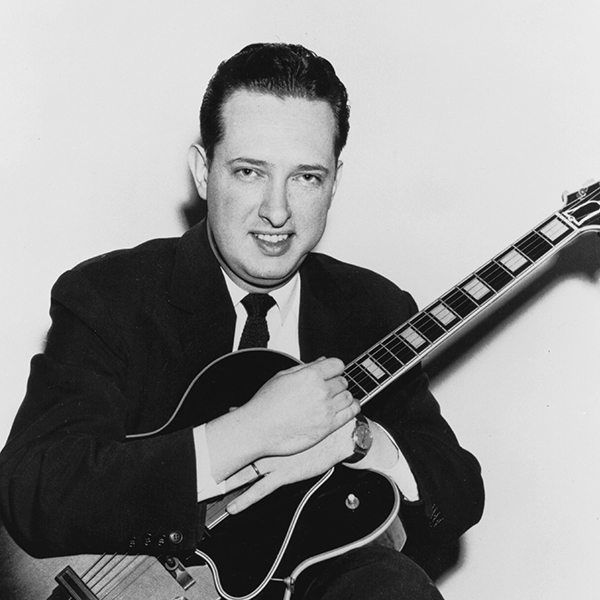 Black and white photograph of Bill Leavitt holding a guitar.