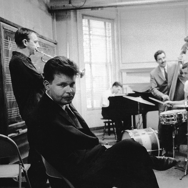 Black and white photograph of men in a practice room rehearsing their quintent act.