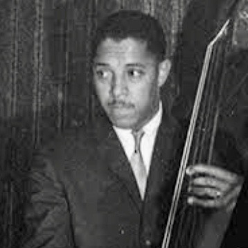 Black and white portrait of man playing the bass.