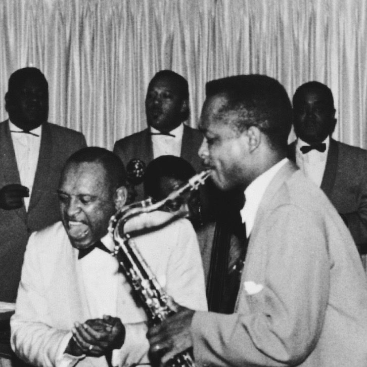 Andy McGhee solos with the Lionel Hampton band. Sammy Davis Jr. plays the drums.